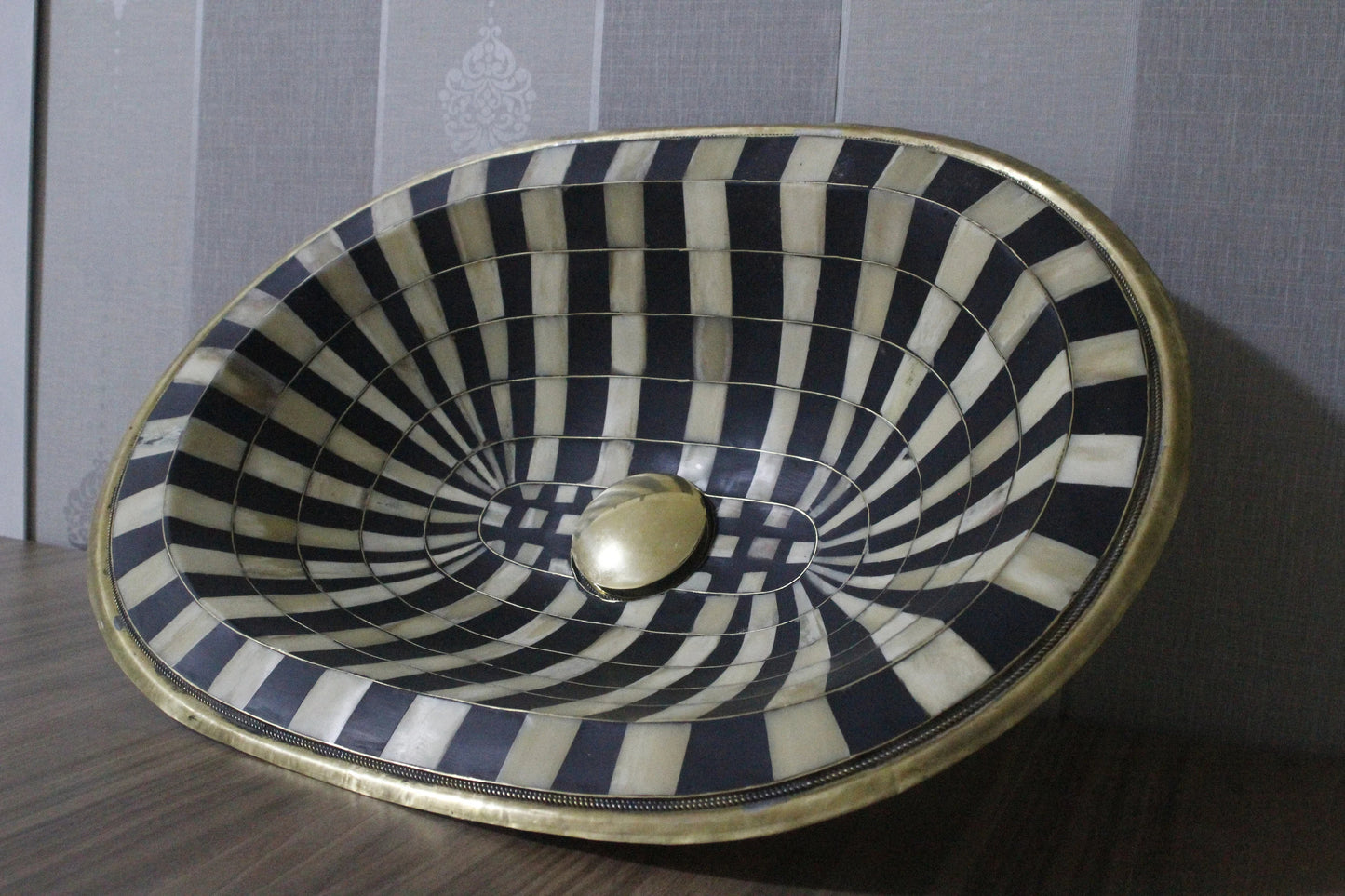 Stunning black and white oval drop-in sink featuring a single hole, resilient brass, and resin basin.