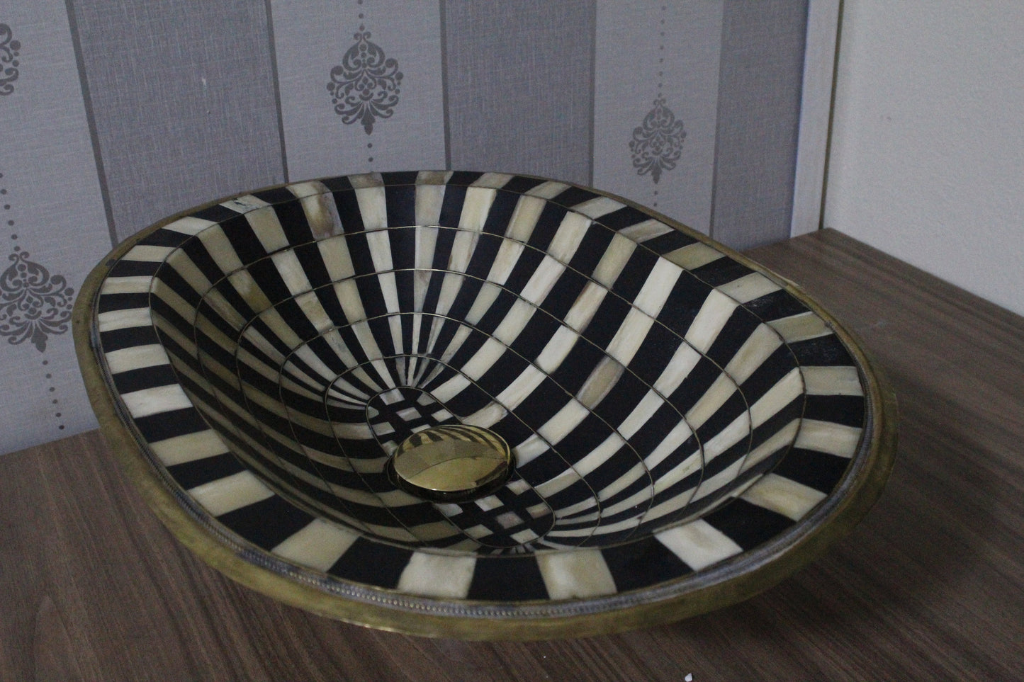 Stunning black and white oval drop-in sink featuring a single hole, resilient brass, and resin basin.