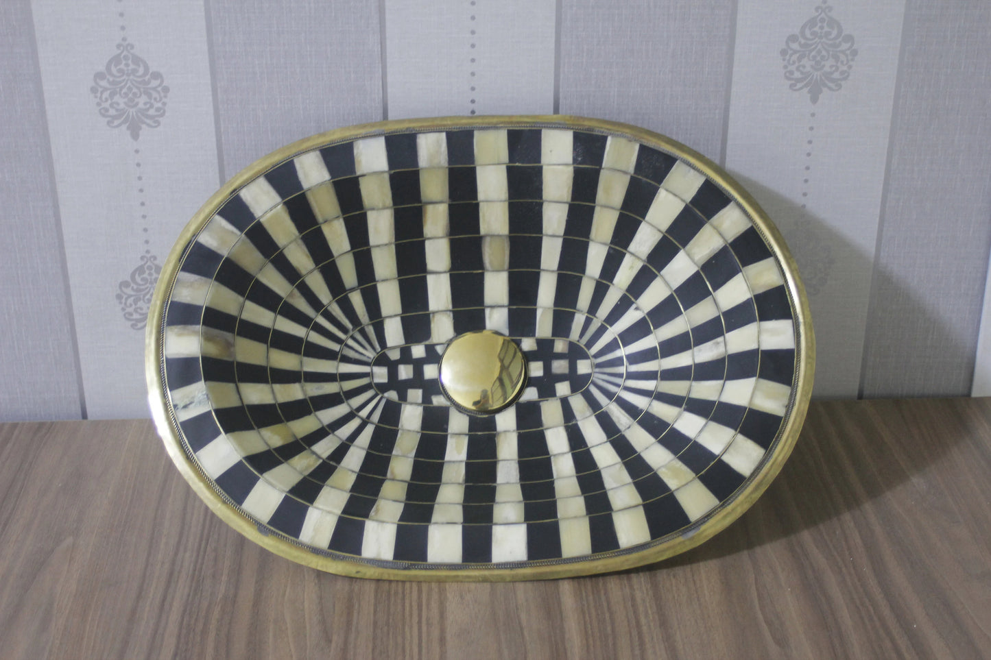 Stunning black and white oval drop-in sink featuring a single hole, resilient brass, and resin basin.